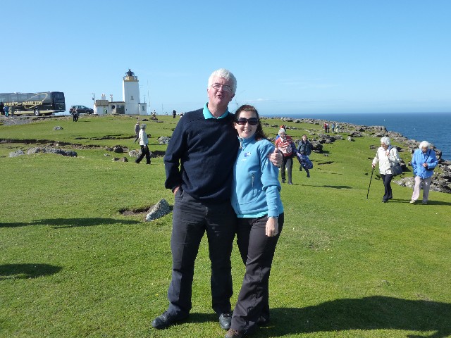 Eshaness lighthouse in the rear - Graham with guide Andy in foreground